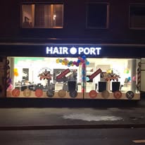 Hairport Barbershop bei Nacht von außen