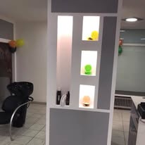 Beleuchtete Produktnischen und Waschplatz im Salon