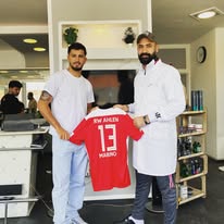 Hairport Besuch mit hochgehaltenem rotem Fußballtrikot