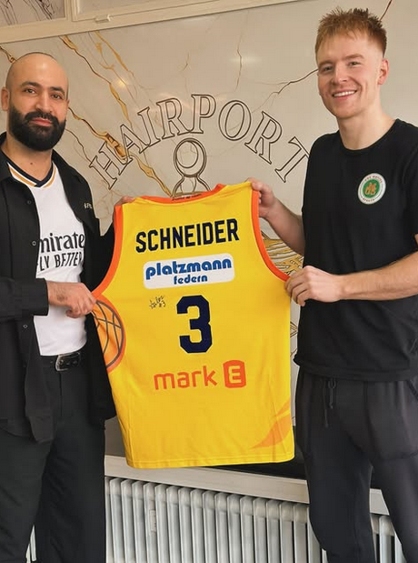 Hairport Besuch mit hochgehaltenem Basketballtrikot